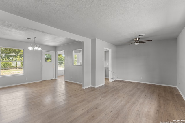 unfurnished room featuring light hardwood / wood-style flooring, a textured ceiling, and ceiling fan with notable chandelier