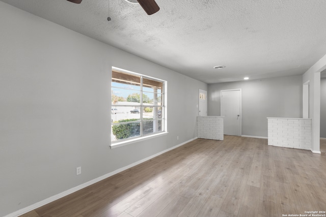 unfurnished living room with light wood-type flooring, ceiling fan, and a textured ceiling