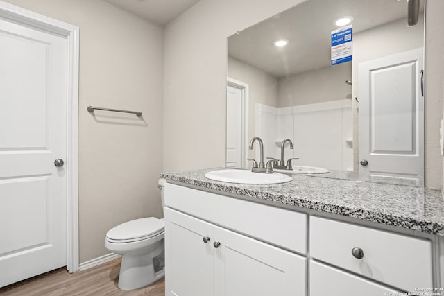 bathroom with hardwood / wood-style floors, vanity, and toilet