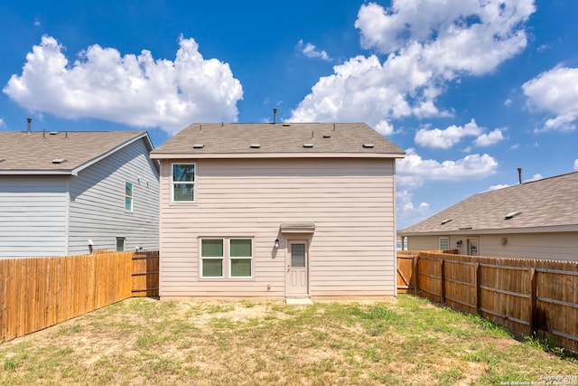 rear view of house featuring a yard