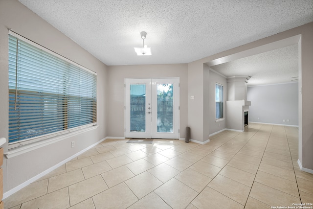 unfurnished room with french doors, a textured ceiling, and light tile patterned floors