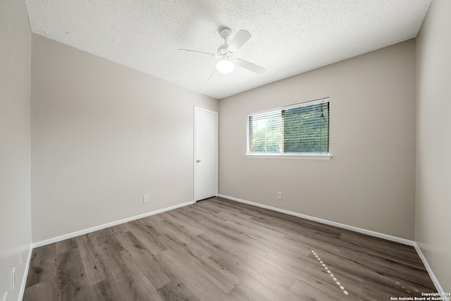 unfurnished room with a textured ceiling, hardwood / wood-style floors, and ceiling fan