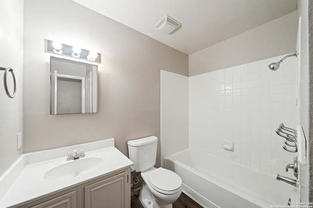 full bathroom with vanity, tiled shower / bath combo, and toilet