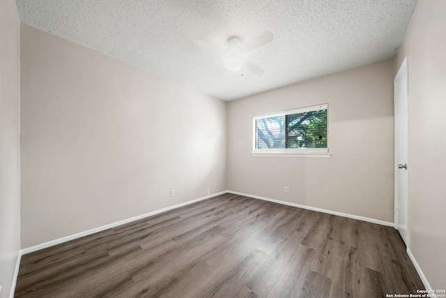 spare room featuring wood-type flooring, ceiling fan, and a textured ceiling