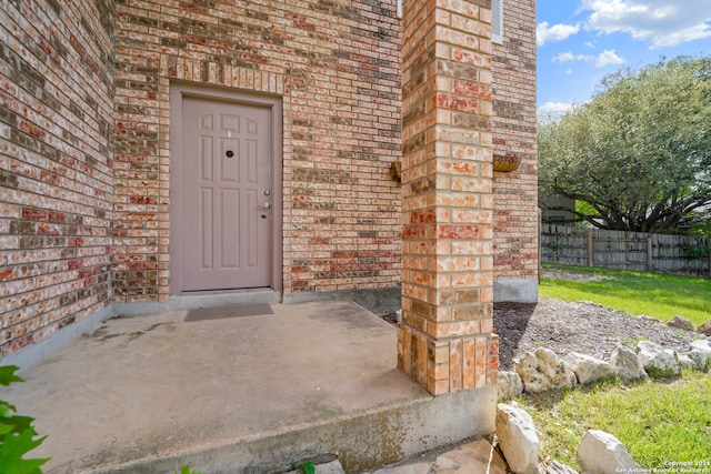 view of exterior entry featuring a patio