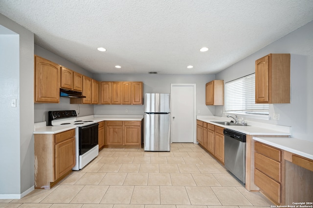 kitchen featuring stainless steel appliances, a textured ceiling, light tile patterned floors, and sink