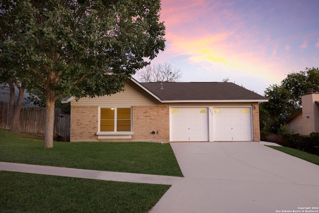 ranch-style house featuring a lawn and a garage