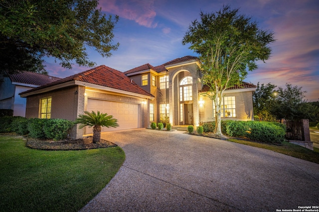 mediterranean / spanish house with a yard and a garage