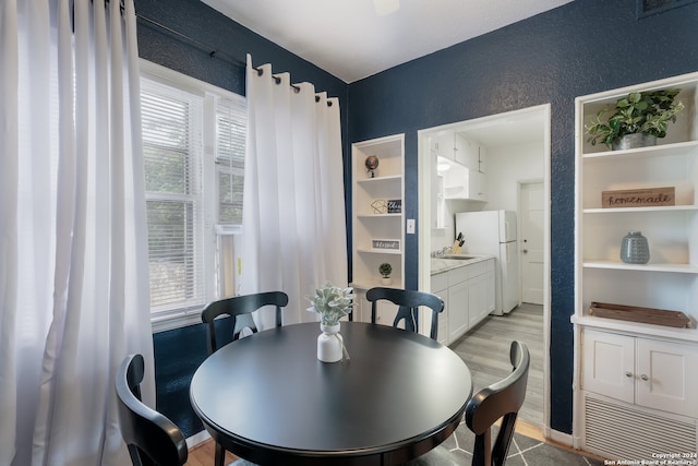 dining space featuring light wood-type flooring and sink