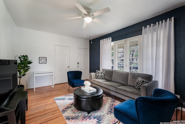 living room featuring wood-type flooring and ceiling fan