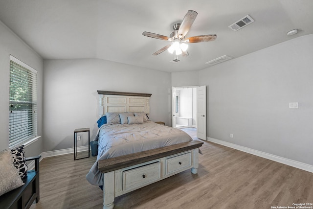 bedroom with light wood-type flooring, vaulted ceiling, and ceiling fan