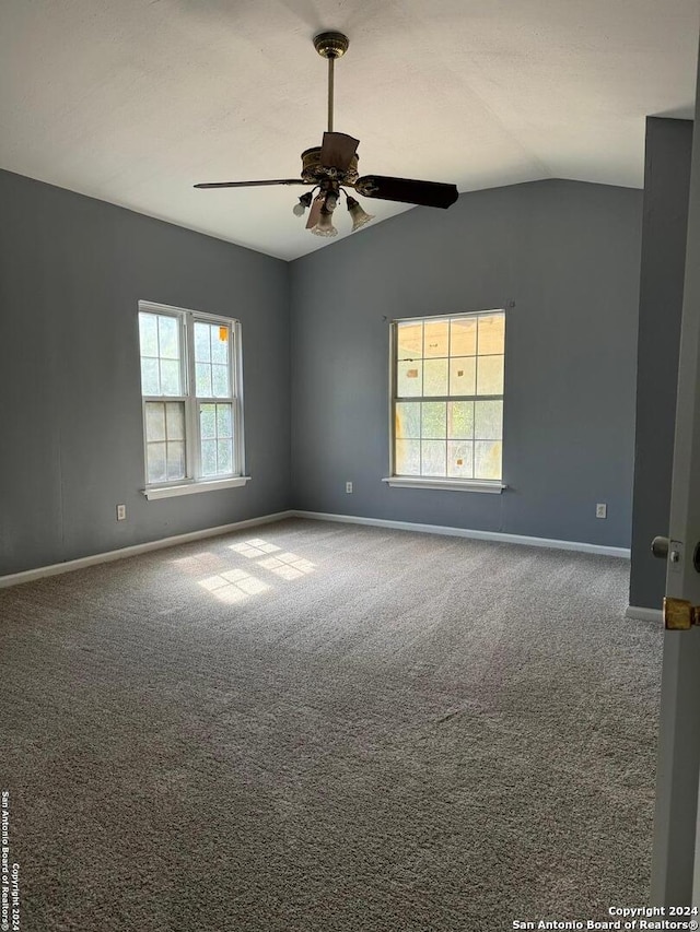 spare room featuring ceiling fan, carpet flooring, and vaulted ceiling