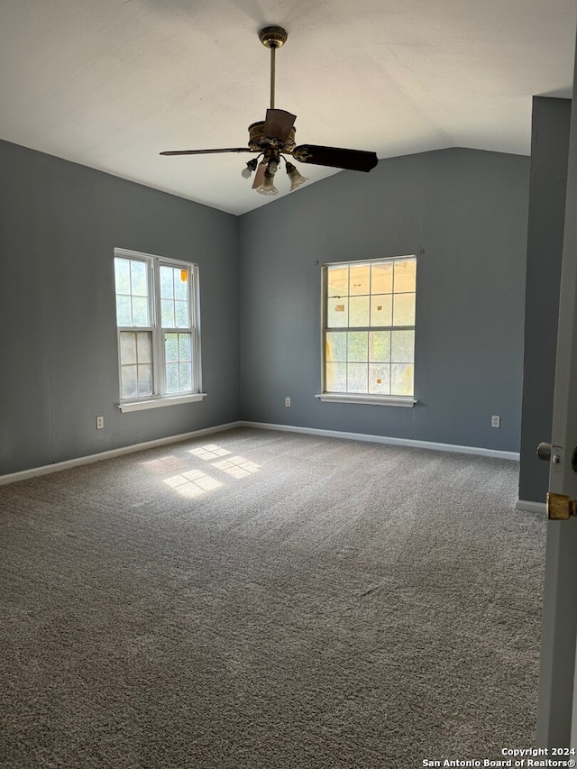 empty room featuring carpet, vaulted ceiling, and ceiling fan