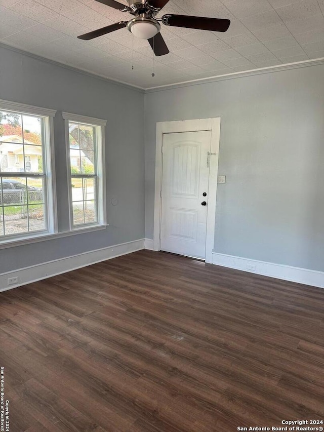 empty room featuring ornamental molding, ceiling fan, and dark hardwood / wood-style floors