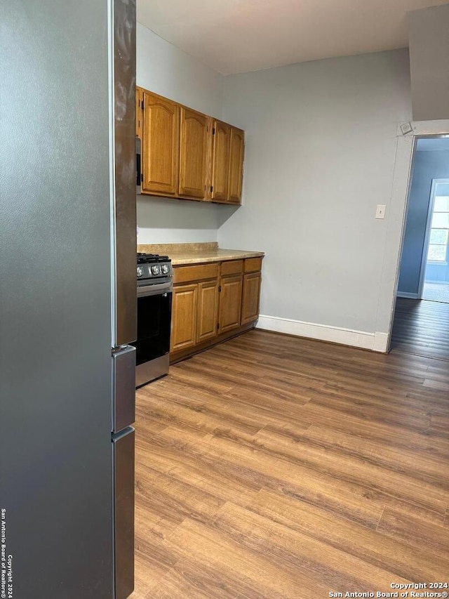 kitchen with stainless steel fridge, light hardwood / wood-style floors, and range