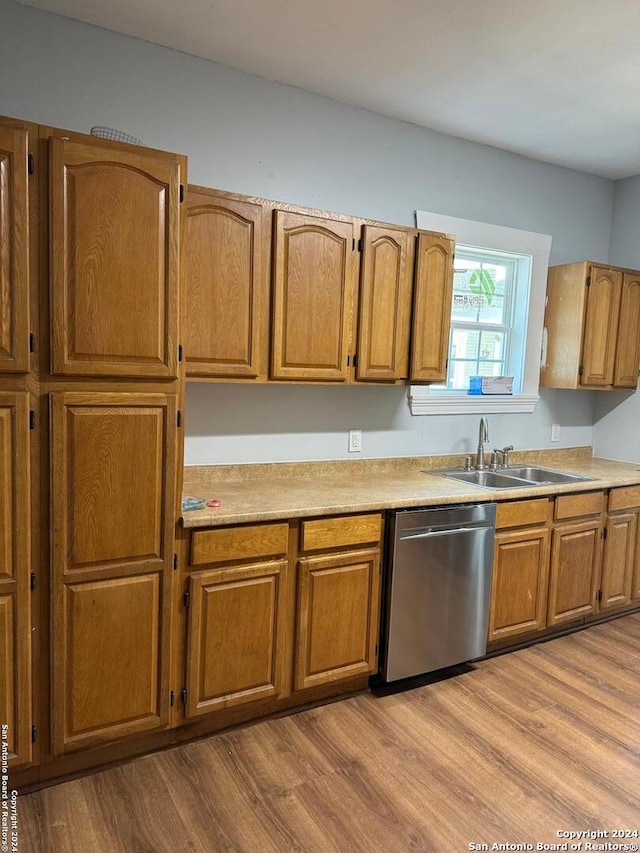 kitchen with light wood-type flooring, dishwasher, and sink