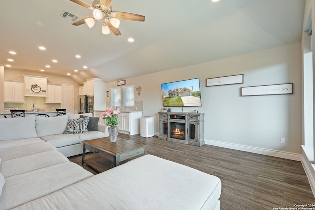 living room with lofted ceiling, ceiling fan, and dark wood-type flooring