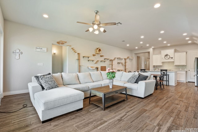 living room featuring light wood-type flooring and ceiling fan