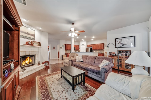 living room with ceiling fan, dark hardwood / wood-style floors, and a fireplace