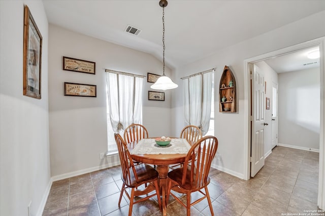 tiled dining space with lofted ceiling