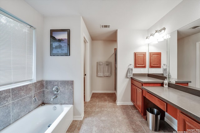 bathroom with tile patterned flooring, vanity, and a tub