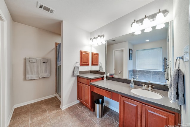 bathroom with walk in shower, tile patterned flooring, and vanity