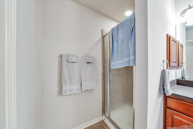 bathroom with a shower with shower door and vanity