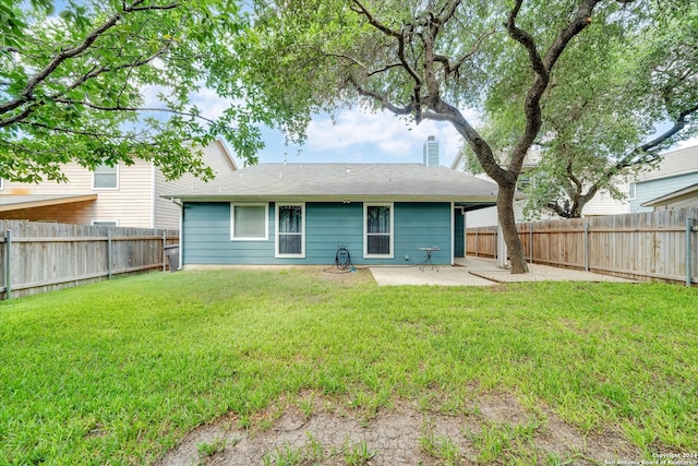 back of house with a patio and a yard