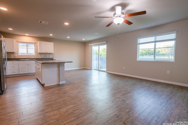 kitchen with light wood-type flooring, white cabinetry, ceiling fan, and a wealth of natural light