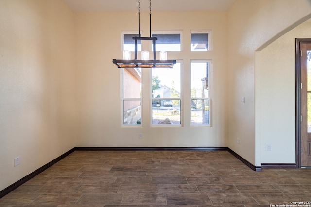 unfurnished dining area with a notable chandelier