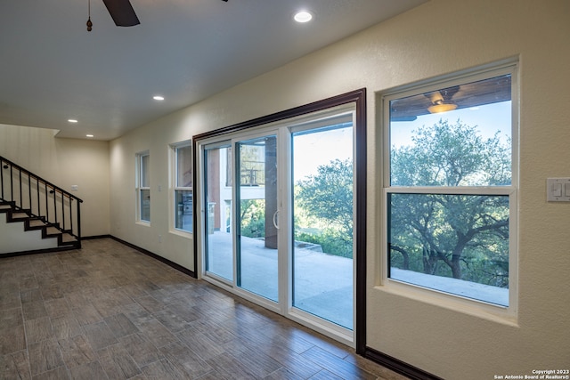 doorway to outside with ceiling fan and dark wood-type flooring