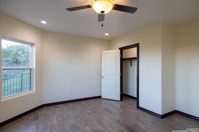 unfurnished bedroom with ceiling fan, a closet, and dark hardwood / wood-style floors