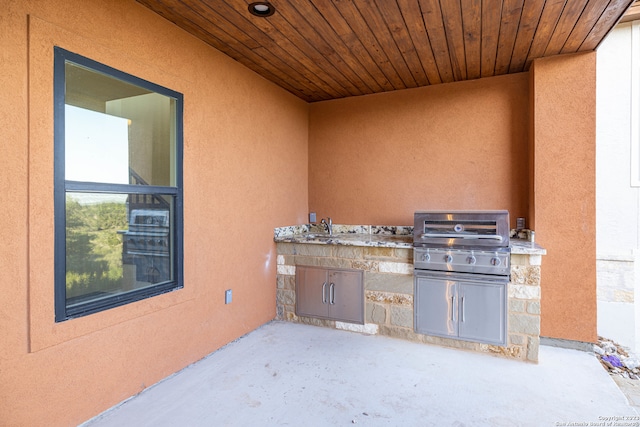 view of patio with exterior kitchen, area for grilling, and sink