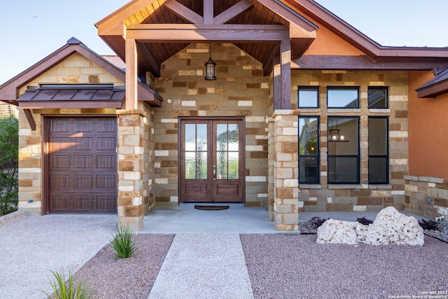 view of exterior entry featuring a garage and french doors