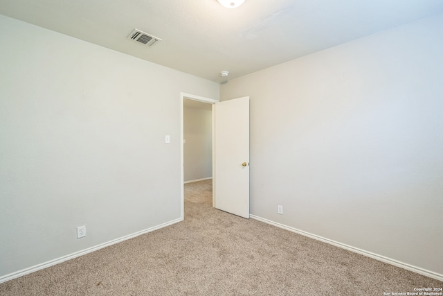 spare room featuring light colored carpet