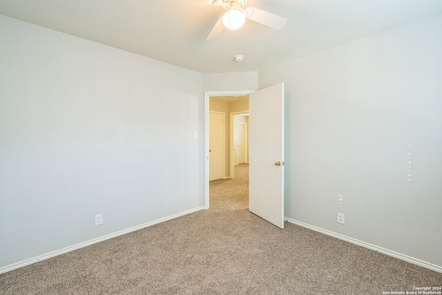 spare room with ceiling fan and light colored carpet