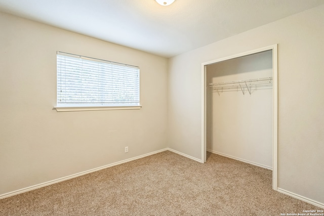 unfurnished bedroom featuring light carpet and a closet