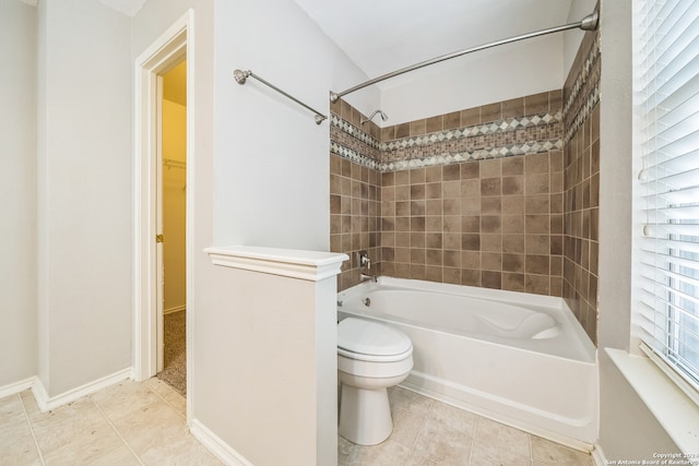 bathroom with toilet, tile patterned floors, and tiled shower / bath