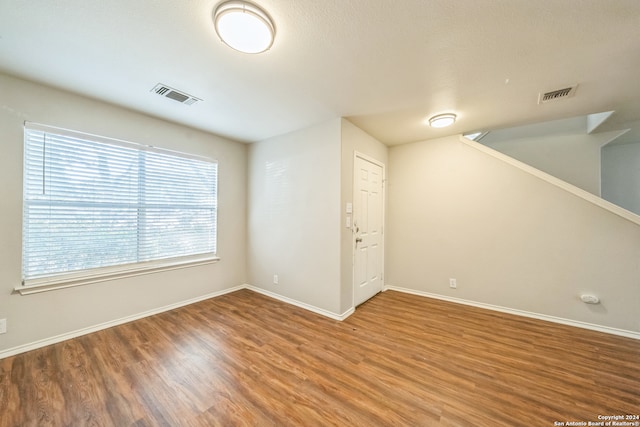 unfurnished room with hardwood / wood-style floors