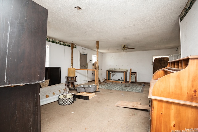 basement featuring a textured ceiling and ceiling fan