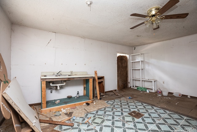 miscellaneous room featuring a textured ceiling and ceiling fan