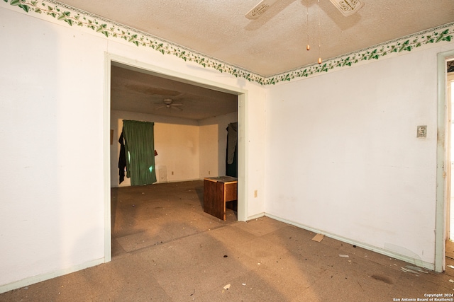 empty room with a textured ceiling and ceiling fan