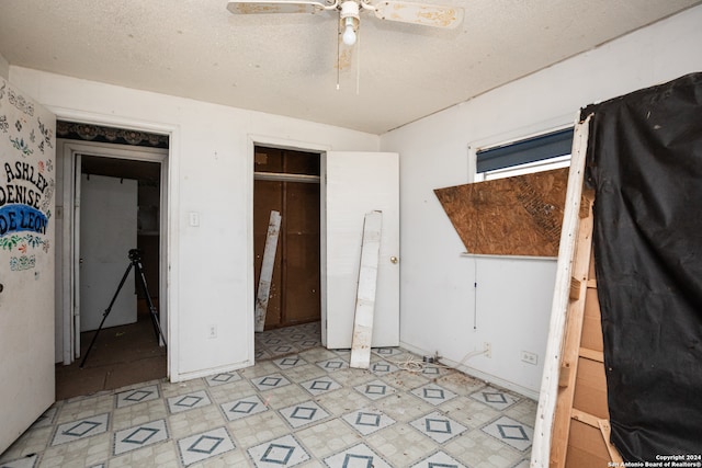 unfurnished bedroom with a closet, ceiling fan, and a textured ceiling