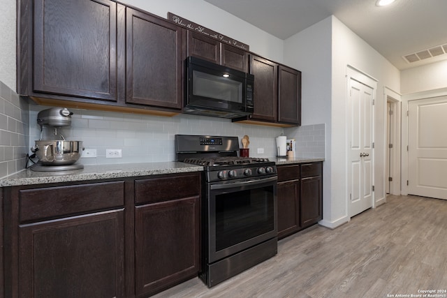 kitchen featuring decorative backsplash, light stone counters, light wood-type flooring, stainless steel range with gas stovetop, and dark brown cabinetry