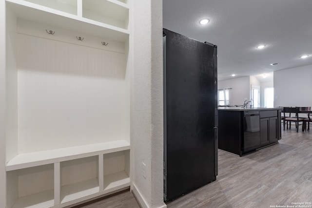 mudroom with sink and light hardwood / wood-style flooring