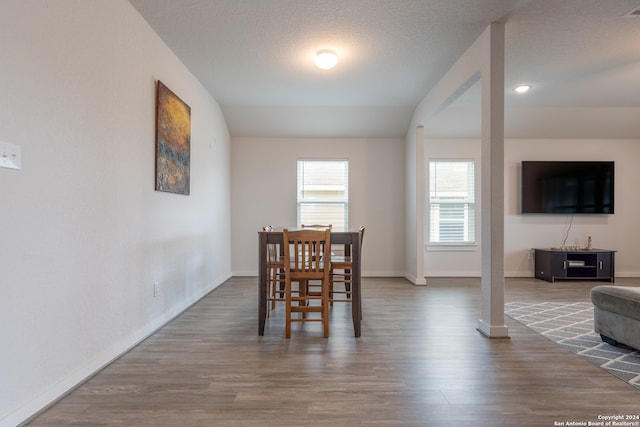 dining space with a textured ceiling and hardwood / wood-style floors