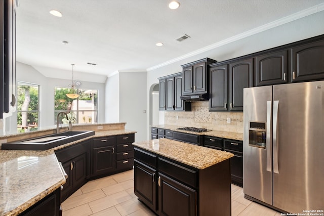 kitchen with light stone counters, a center island, stainless steel appliances, backsplash, and decorative light fixtures