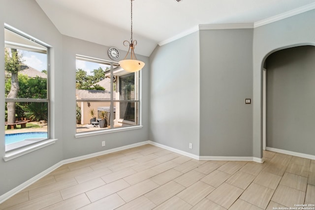 empty room featuring crown molding and vaulted ceiling