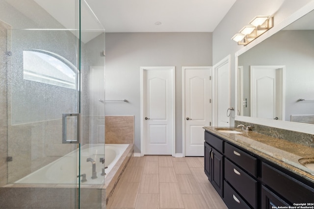 bathroom with vanity and shower with separate bathtub