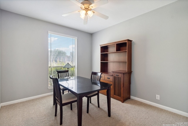 carpeted home office featuring ceiling fan